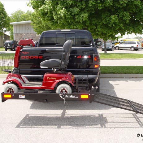 Versahaul mobility scooter carrier installed on back of truck with extended ramp loaded with scooter